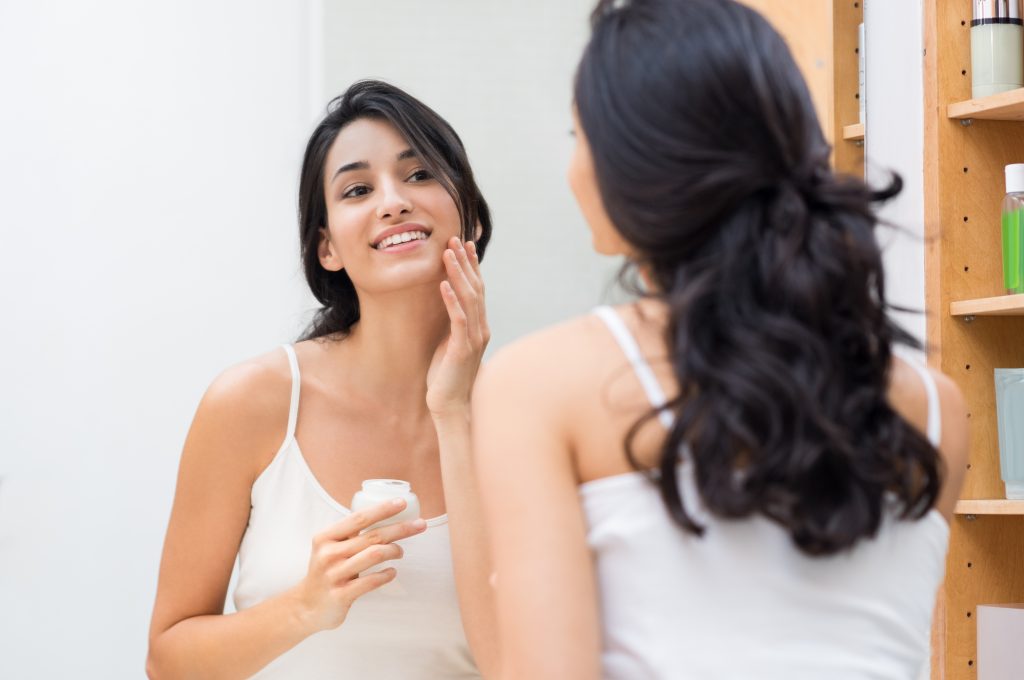 woman applying facial care product