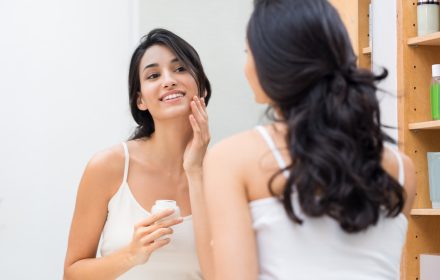 woman applying facial care product