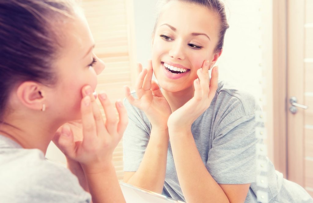woman happy doing her skincare routine